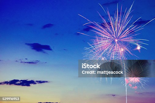 istock Multicolor bursting fireworks against a sun setting sky 529916953