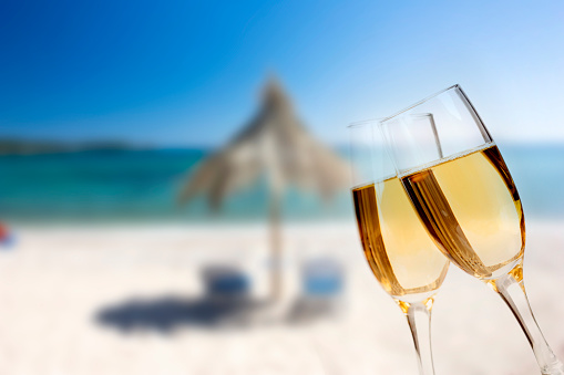 New Year at the beach - Glasses of champagne on the beach against the sky and blue sea