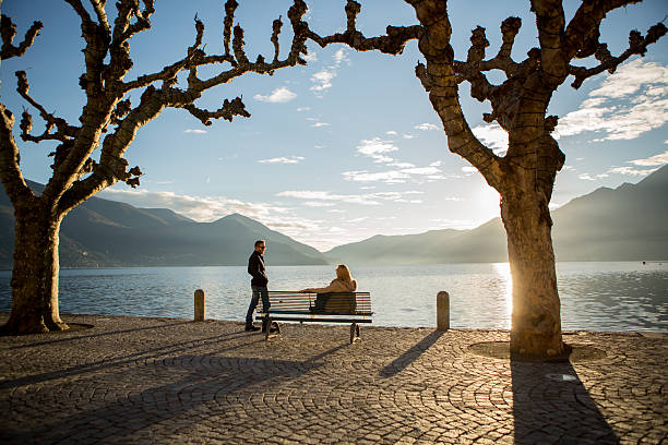 istock Young people on bench at sunset near lake 529918235