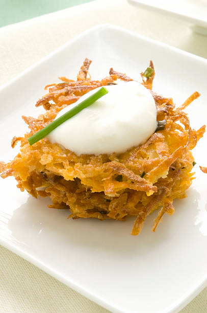 Sweet Potato Latkes with Sour Cream and Chive Garnish stock photo