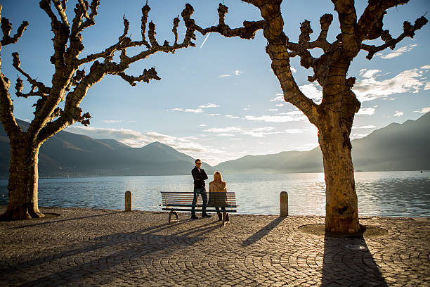 istock People sitting on bench near lake talking-Europe 529919951