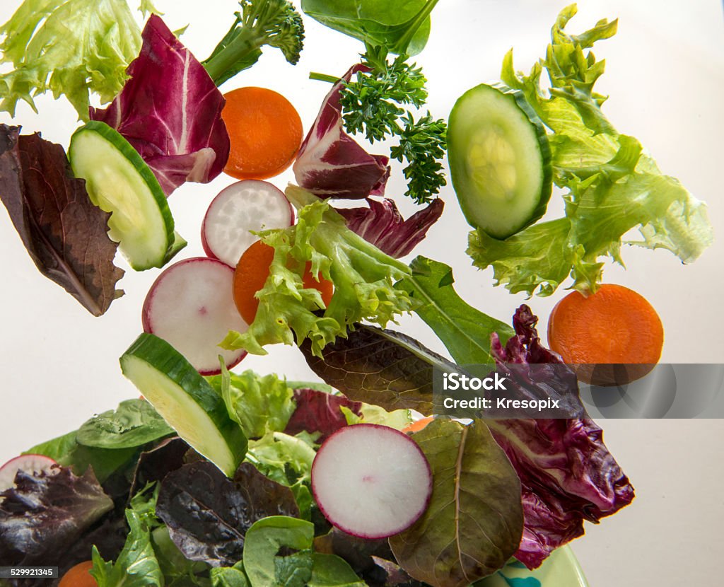 Tossed fresh salad Mixed Fresh Salad being tossed in the air Throwing Stock Photo