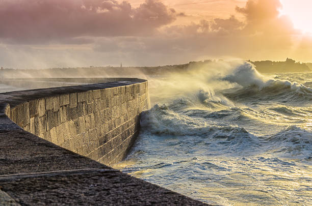Big waves crushing on stone pier stock photo