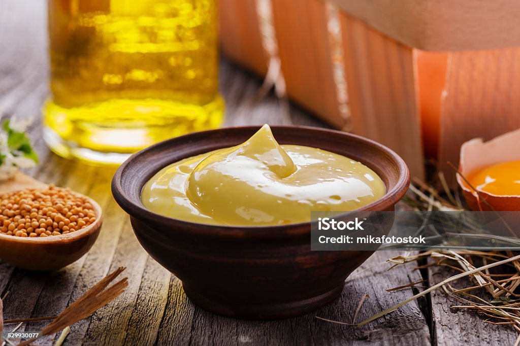 homemade mayonnaise into a bowl on a wooden surface Appetizer Stock Photo