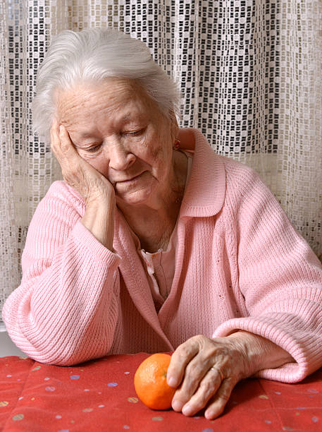 istock Old woman looking at tangerine 529931119