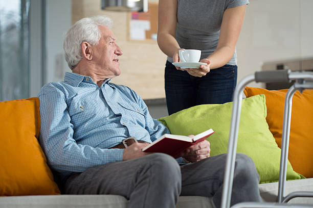 istock Carer giving disabled man coffee 529933753