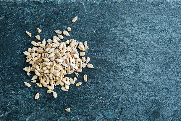 istock Peeled sunflower seeds on stone substrate. Closeup 529947593