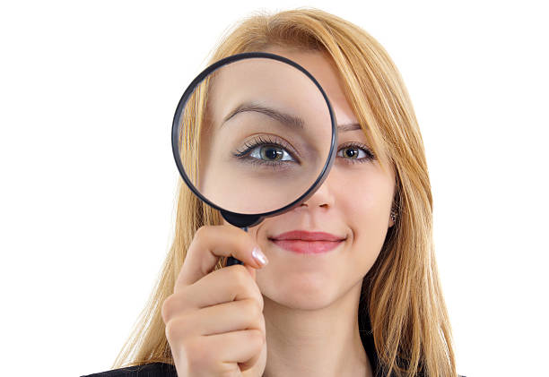 Beautiful woman looking through a magnifying glass