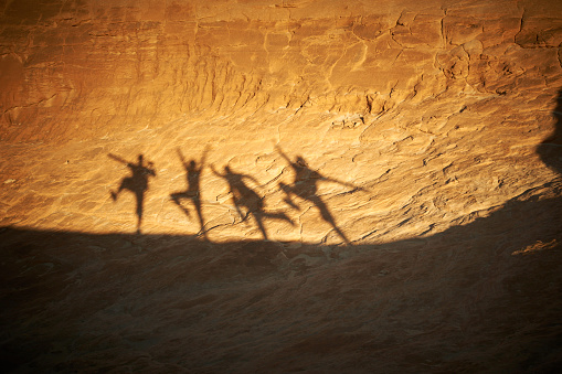 shadows of people on a rock in the desert