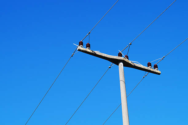 Power lines against blue sky stock photo