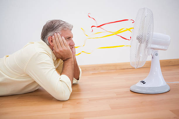 istock Man lying on floor looking at fan 529966909