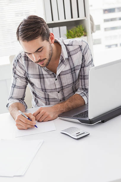 istock Casual businessman writing at his desk 529966933