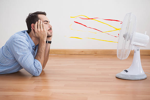 Casual man lying in front of fan
