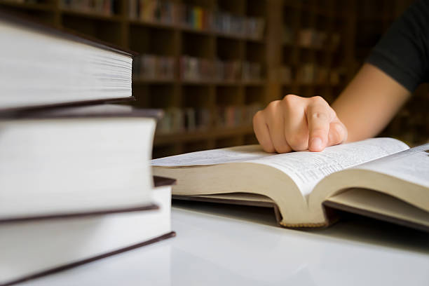 istock Woman reading book in library. 529978018