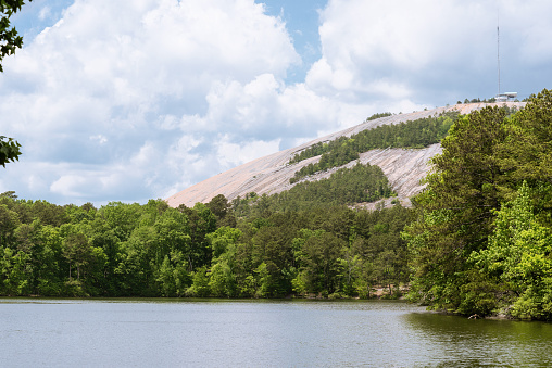 Stone Mountain, Georgia is seen across a pristine lake surrounded by woods.