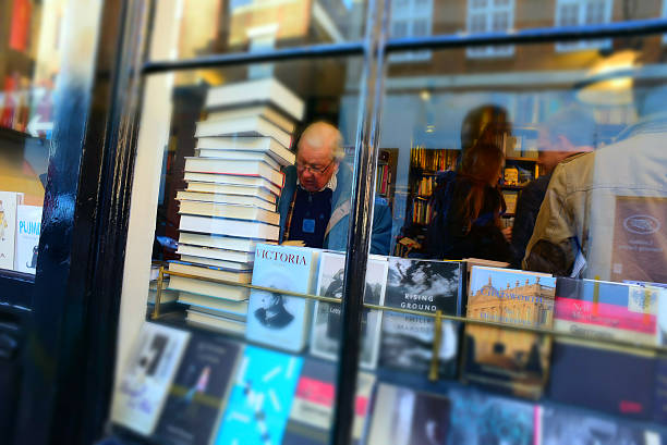 London, England, UK - Dec 13, 2014. The display of the small but prominent bookstore, John Sandoe Books, in London, U.K. captured on Dec 13, 2014 from outside, where Christmas shopping craze is at full speed. Inside of the shop, a senior man is checking out a book, while  the small shop is full with other customers.