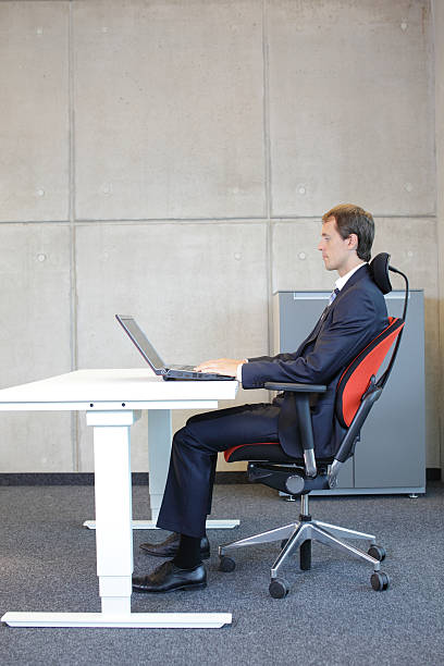 istock man in suit in correct sitting position at workstation in office 529981537