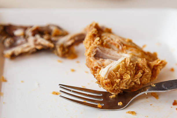 Plate with remnants of fried chicken in the restaurant