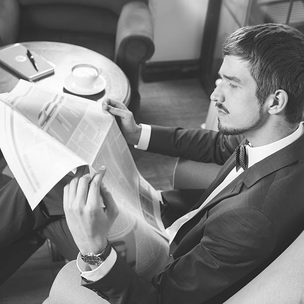 istock Businessman reading a newspaper at cafe, mourning 529982496