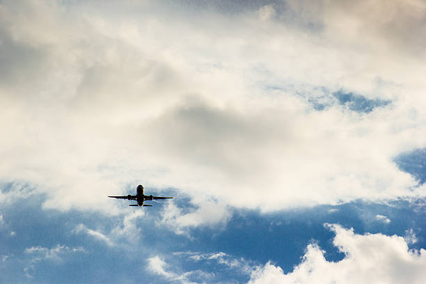 istock airplane flying in the blue sky with clouds 529983174