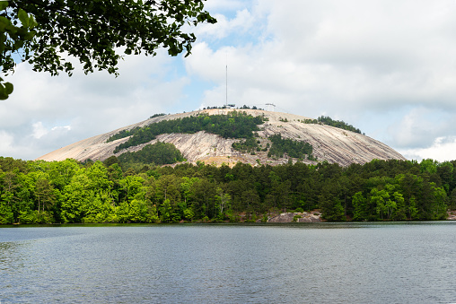 Stone Mountain looms large from across a lake. This is the side without the confederate soldier carvings. Set in the woods on a pristine lake.