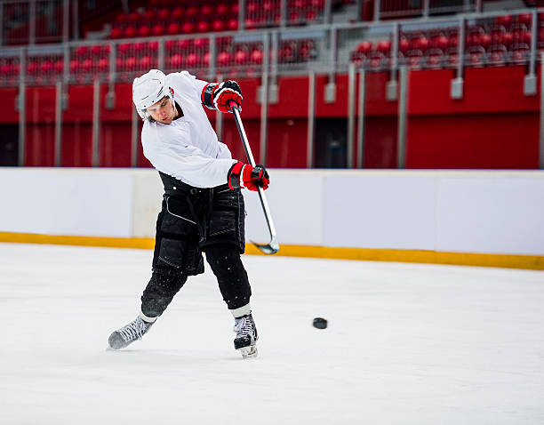 jugador de hockey sobre hielo tiro a portería - ice hockey hockey puck playing shooting at goal fotografías e imágenes de stock