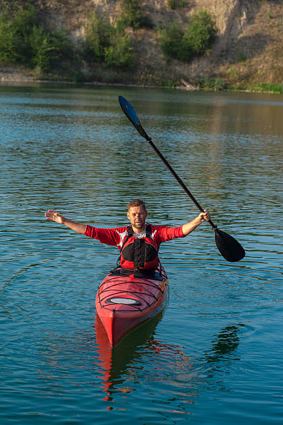 istock man kayaking and holding oar over head 529984032