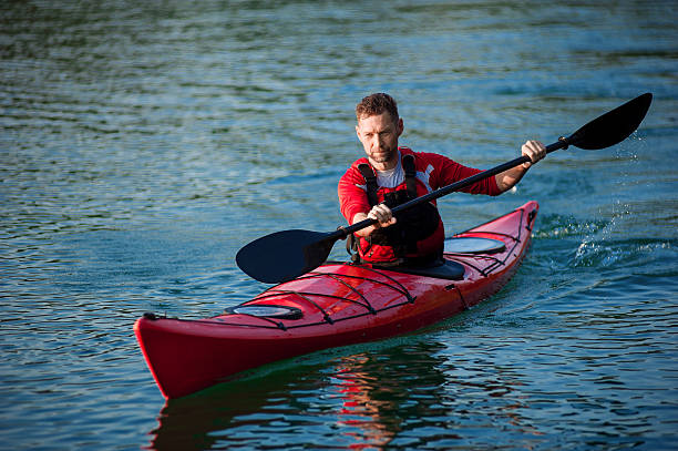 спортивный человек в красной каяке расы - rowboat river lake nautical vessel стоковые фото и изображения