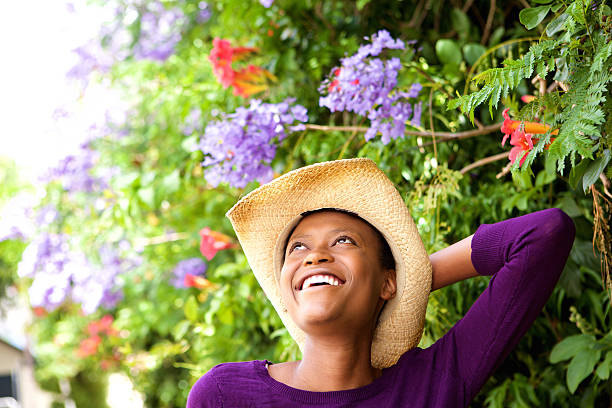 Close up portrait of smiling young female with hat standing outdoors and looking away