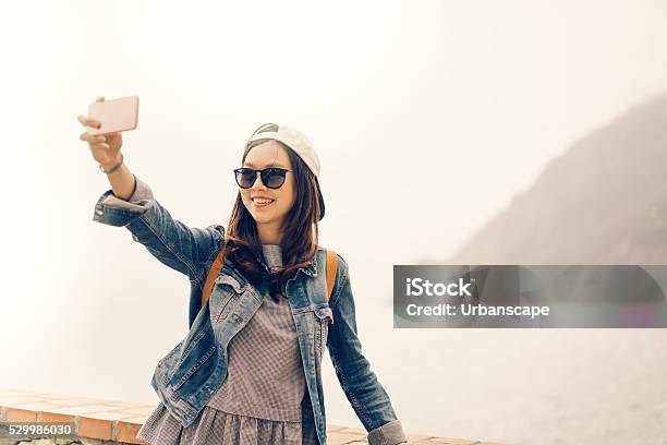 Asian Traveler Taking Selfie With Ocean View Soft Warm Tone Stock Photo - Download Image Now