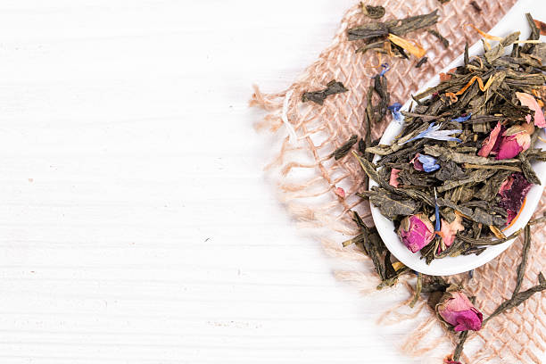 istock green tea, dried leaves, on wooden background 529987514