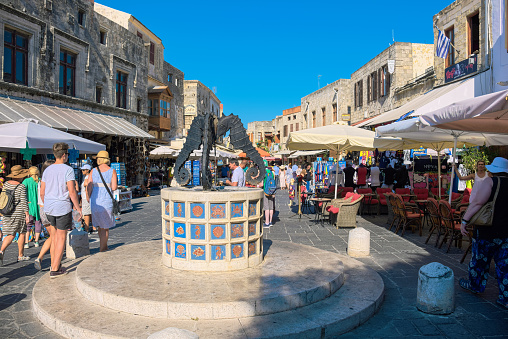 Rhodes, Greece – July 4, 2015: Tourists visiting and shopping at square of the Jewish Martyrs in the historic old town of Rhodes