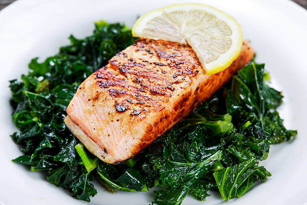 Pan fried Salmon Served with Kale on plate Pan fried Salmon Served with Kale on plate. sockeye salmon filet stock pictures, royalty-free photos & images