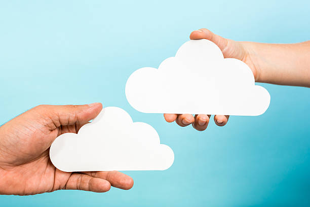 Two hands holding white empty clouds. Cloud computing storage concept stock photo