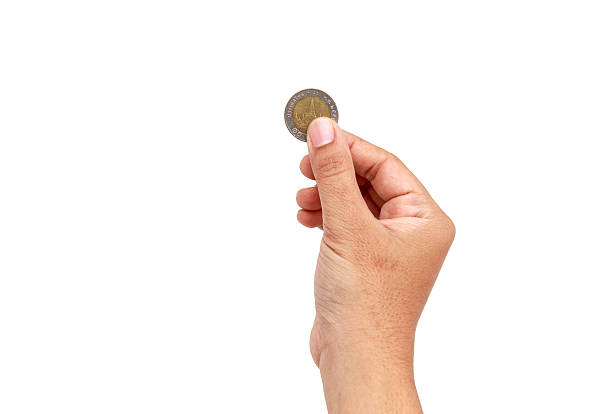istock Woman hand holding coin isolates on white background 529993529