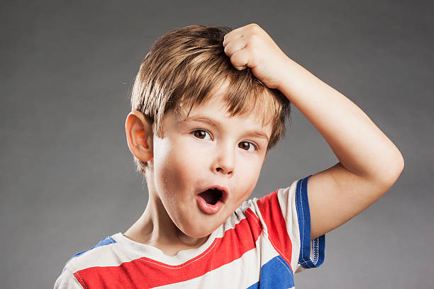 istock Young boy looking amazed against gray background, portrait 529994797