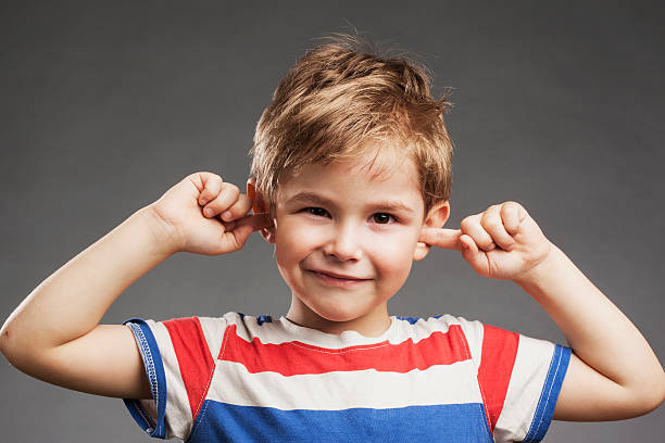 젊은 남자아이 커버링 귀 against 회색 배경 - human ear inconvenience child covering 뉴스 사진 이미지