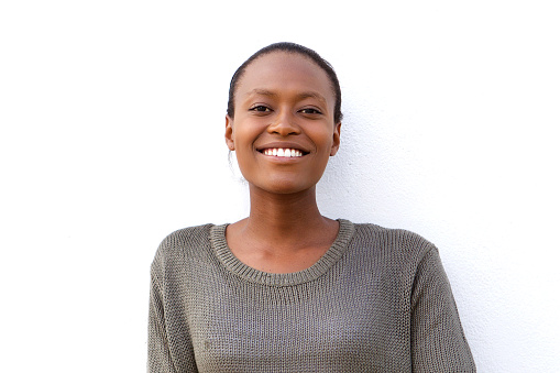Close up portrait of beautiful young african woman smiling against white background