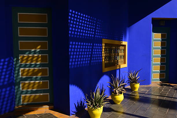 Majorelle gardens, Marrakech, Morocco, Africa. Marrakech, Morocco.  - February 21, 2016: The world famous garden of Jardin Majorelle created by Jacque Majorelle in the 1930's which he used as his art studio, After his death in the 60's and just before demolition it was saved by Yves Saint Laurent and associates in the 80's. The building has been restored and the studio is a museum finished off with beautiful gardens. Proceeds from tourists visiting is split between local and worldwide charities. park designer label stock pictures, royalty-free photos & images