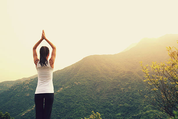 istock young woman practice yoga at mountain peak cliff 529995076