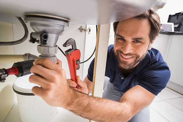 Plumber fixing under the sink Plumber fixing under the sink in the kitchen Plumber stock pictures, royalty-free photos & images