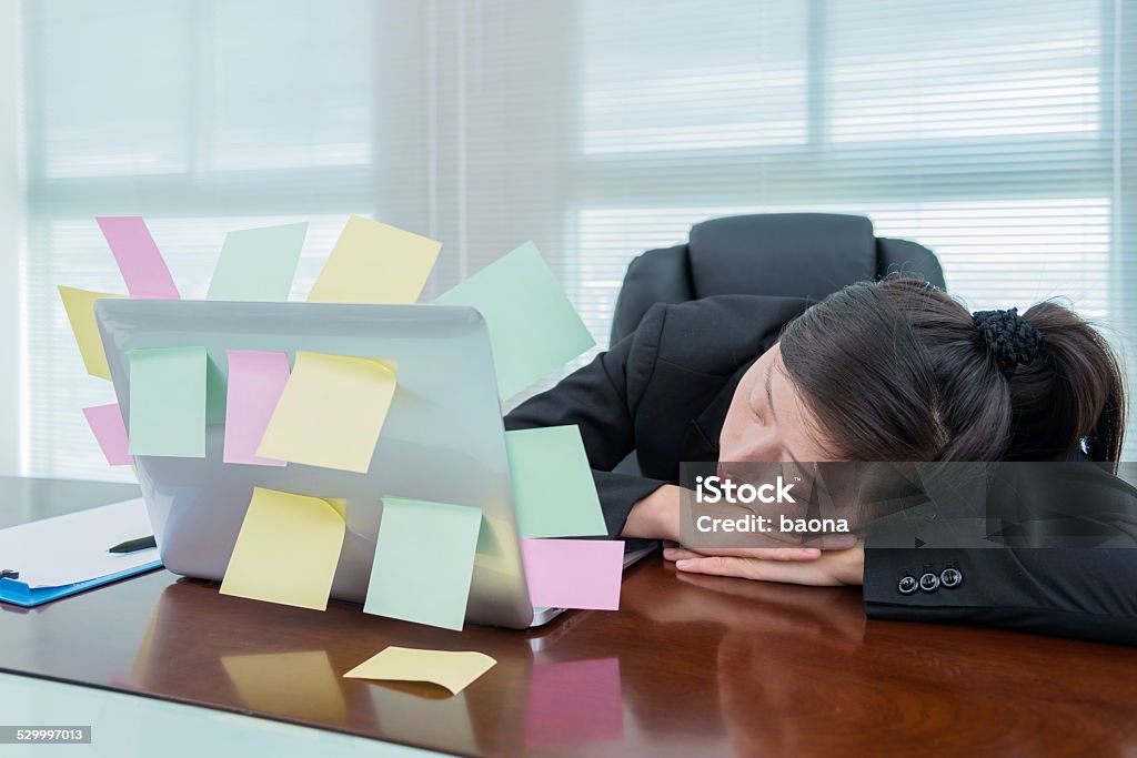 sleeping at laptop Businesswoman sleeping in office, with many adhesive notes on laptop. Adhesive Note Stock Photo