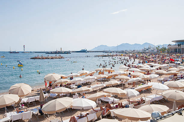 People relax on the beach during the high season. stock photo