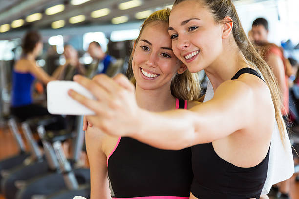 istock Two sporty young woman using mobile phone in gym. 530001414