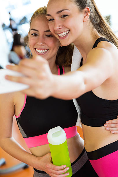 istock Two sporty young woman using mobile phone in gym. 530001518