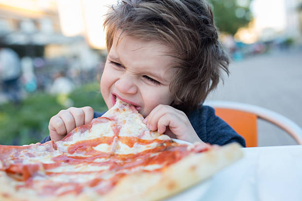 istock Small boy eating pizza for a lunch. 530002770