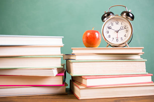 istock Back to school time. Education. Textbooks, alarm clock, chalkboard. 530002924