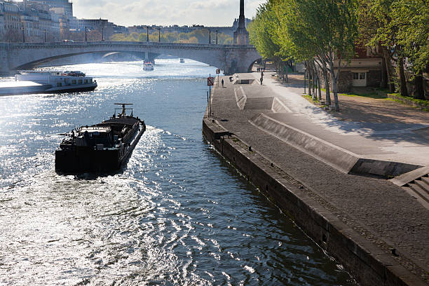 barge on sparkling river seine in paris by quay morning