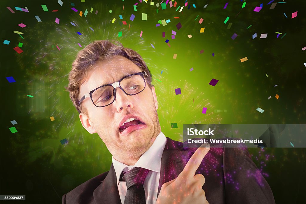Composite image of young geeky businessman pointing to shoulder Young geeky businessman pointing to shoulder against colourful fireworks exploding on black background Exploding Stock Photo