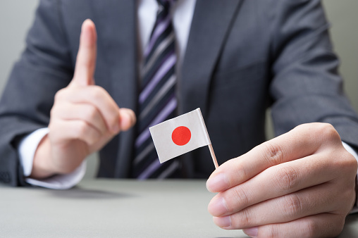 Hand holding a Japanese flag